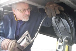 Manual grease guns, such as the one used on this landing gear, are recommended over air-powered guns to avoid forcing grease into the fitting too rapidly. Use a grease gun that holds a large volume of grease and has a long handle that gives you a large mechanical advantage.