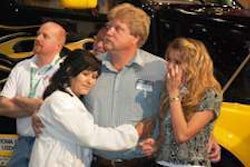 Winner Robert Snyder, flanked by his wife, Sylvia, and his daughter, Savannah, in front of the prize Volvo VNL 670, joins the audience in watching a video about his family.