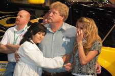 Winner Robert Snyder, flanked by his wife, Sylvia, and his daughter, Savannah, in front of the prize Volvo VNL 670, joins the audience in watching a video about his family.