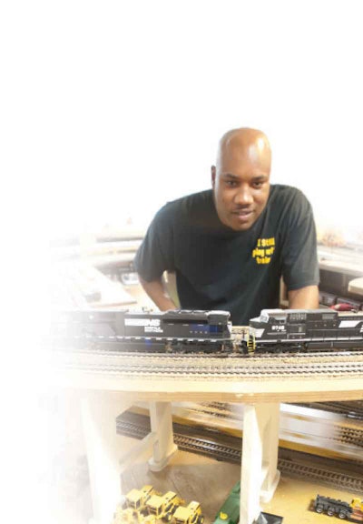 A yard for trucks and other heavy-duty equipment is part of the landscape surrounding the model train tracks where owner-operator Leonard Roberson practices his hobby.