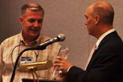 Trucker Buddy’s Randy Schwartzenburg (right) gives Randall-Reilly CEO Mike Reilly a plaque in appreciation of his support for Trucker Buddy.