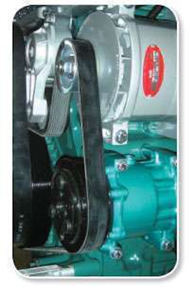 This Volvo D16 has a typical serpentine belt setup. To remove the belt, turn the tensioner, which is behind the alternator, counter-clockwise. Small cracks in belt grooves indicate a need for replacement.