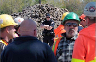 Drivers protest as a policeman stands gaurd at the Windsor-Essex Parkway project this weekend. (Photo from The Windsor Star website.)