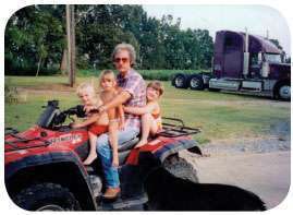 Dedication to family parallels work ethic, shown here in 2003 with grandkids and the first truck he ever purchased.