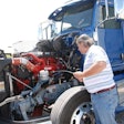 Equipment Editor Jack Roberts checks the oil in the ISX15 in this Peterbilt 386, which serves as a test vehicle at a Cummins research facility in Indiana.