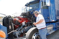 Equipment Editor Jack Roberts checks the oil in the ISX15 in this Peterbilt 386, which serves as a test vehicle at a Cummins research facility in Indiana.