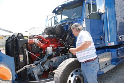 Equipment Editor Jack Roberts checks the oil in the ISX15 in this Peterbilt 386, which serves as a test vehicle at a Cummins research facility in Indiana.