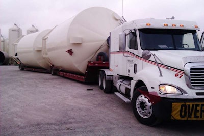 These lowboy doubles loaded with portable grain bins bound for Beach N.D., says driver Micky Conard, measured 16 feet wide, 18 high, and with an overall length of 95 feet. Conard drives for “Meridian Manufacturing out of the Storm Lake, Iowa, plant.”