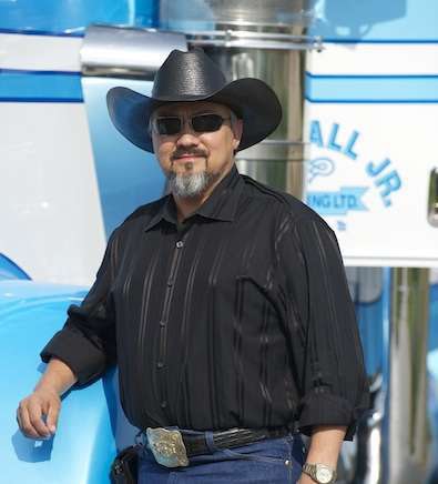 Bill Hall, Jr., standing with one of his show trucks, El Patron.