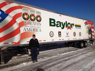 Baylor Trucking, Inc. President, Robert Baylor stands by the trailer which was used to deliver to several military cemeteries. This is the sixth straight year Indiana’s Baylor Trucking has partnered with Wreaths Across America.