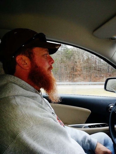 George Parker folds himself into a four-wheeler.