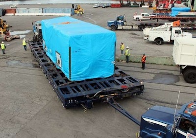 The 562,000-lb. generator unit pictured here, a separate piece of the haul, moved on a “24-line dual-lane Scheuerle trailer at the offload at the Port of Long Beach.” From there, an 800-ton gantry was used to “load it to railcar, then back to a Scheuerle trailer in Cochise, Ariz., for the border crossing and final leg of the haul to Agua Prieta.
