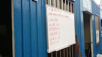 The brokers write their available loads on dry erase boards outside the office.