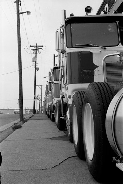 “The Kenworth dealer was right across the street from the Dart terminal in St. Paul, and I used to go over and eye the new K100s all the time. If I’d have been smart I would have taken the money I’d saved and gotten into a better truck, and stayed with Dart running for myself. I guess I just wasn’t mature enough to know the difference yet.” –Craig Ryan on the KW dealer pictured above in the 1970s