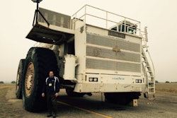 Trucking journalist David Kohlman stands by the M200 tires, which are almost 13 feet tall and weigh 12,000 pounds.