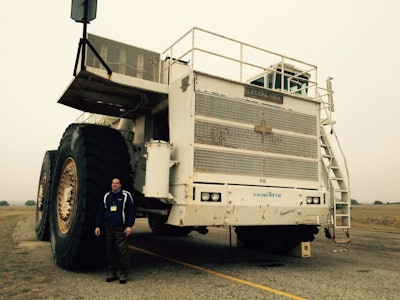 Trucking journalist David Kohlman stands by the M200 tires, which are almost 13 feet tall and weigh 12,000 pounds.