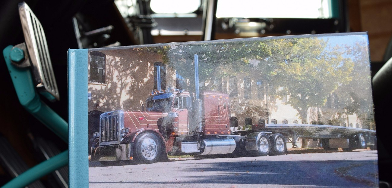 The rig's driver, Kiegan Nelson, notes the unit was found under the ownership of an operator in Minnesota two years back, after which the fleet put it into service -- the picture here graces the cover of a small book on display with the unit that gives show visitors a window into its transformation.
