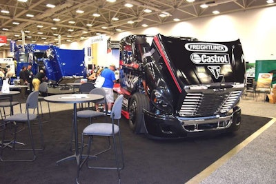 Mike Ryan's Freightliner racer in the Overdrive booth. Ryan is signing autographs and meeting attendees.