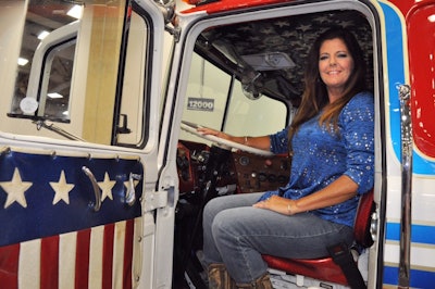 Joanne Fatta, winner of Overdrive's Most Beautiful contest, gets behind the wheel of the antique Mack cabover that hauled equipment for the daredevil Evel Knievel. Mack Trucks is sponsoring a tour of the newly renovated truck.