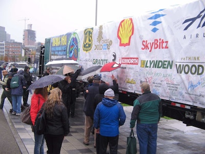 During the community event at Lake Union Park in Seattle, visitors sign banners on the sides of the trailer to wish the tree well on its journey.