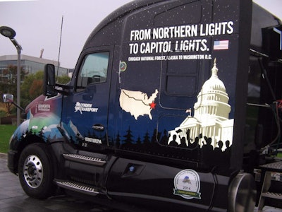 The Kenworth T680’s distinctive decal design features the Chugach Mountains and the U.S. Capitol beneath a northern starry sky with the words “From the Northern Lights to Capitol Lights.” It includes the 2015 Capitol Christmas Tree official seal, a map of the tour route across the United States, and the Alaska state logo of Lynden Transport, a long-time Kenworth customer based in Anchorage.