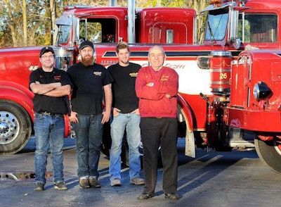 Richard, Rich, Rob, and Kevin Smith standing in front of the Dirty Dozen Kenworth