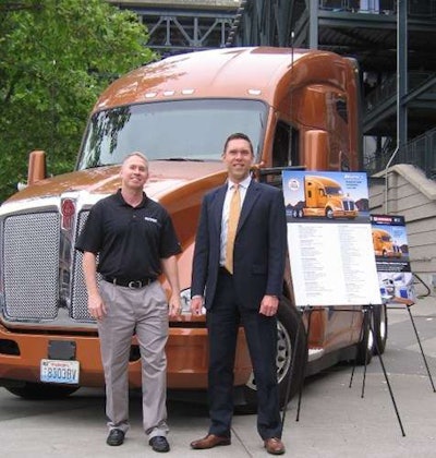 Brad Bentley, president of Fastport (left), and Kurt Swihart, Kenworth marketing director, are shown with the Kenworth T680 76-inch sleeper that will be awarded to trucking’s top military veteran rookie.