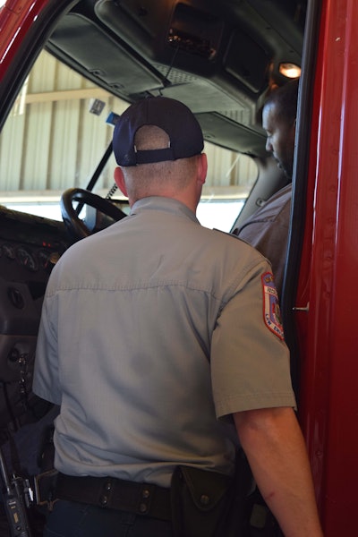 Haralson instructs U.S. Xpress driver Antonio Johnson on the next step in the Level I inspection process. The truck inspection has been completed at this point, and Haralson will now review Johnson’s logs, paperwork, license, medical card and more to fully complete the inspection.