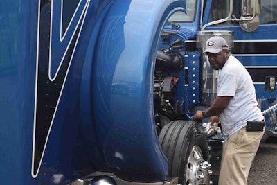 Warren Wiseman, driver for Eric Turner’s Atlanta-based Turner Transport small fleet, putting the finishing touches this morning on Turner’s 2015 Peterbilt glider, showing with an open car haul trailer.