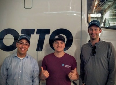 Tsybaev (center) with Otto cofounders each wearing the other company’s hat.