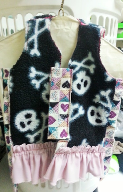 This is a ruffle-covered tactical vest for an infant with no neck.