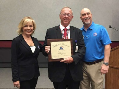 Gloria Clements (left), Gary Killian (center) and Randy Schwartzenburg (right) stand together at the Mid-America Trucking Show.