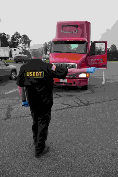 Man performing roadcheck inspection on truck