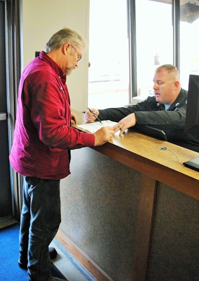 Trucker David Bell and Ky. Sergeant Jason Morris conferring on Bell’s inspection report.