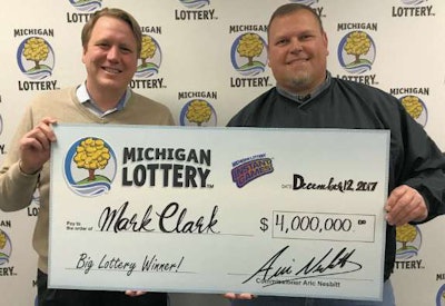 Driver Matt Clark, right, receives his $4 million check after winning the Michigan lottery last week.
