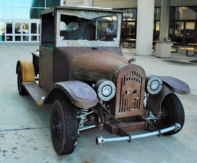 The cowling and running boards of the rat are from a 1926 International pickup. It’s powered by a 200cc Honda engine.