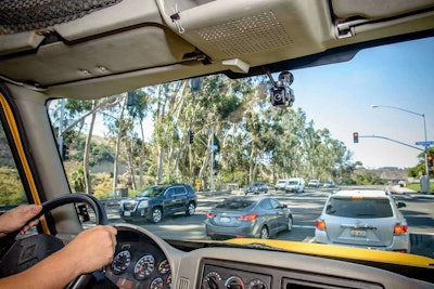 The new SR4 central dual-camera set up (shown in the center high on the windwhield) and multicamera-capable platform uses smaller in-cab cameras than prior generations of the tech, with a more flexible footprint. Photo courtesy of SmartDrive