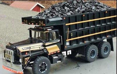 The truck, David says, is built at 1/25th scale. “Everything is to scale,” including the tube-type tires. The model measures 15 inches from the front bumper to the back of the tailgate, to give you an idea of actual size, standing 5.5 inches to the top of the bed. The shovel shown here on the side of the bed is made of metal and wood. The truck has metal mack bulldog door mirrors ,and metal fender mirrors metal bulldog on the radiator.