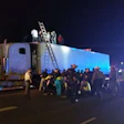 Immigrants exiting trailer surrounded by officers