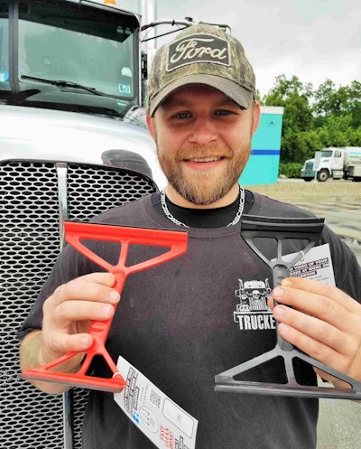 Pittsburgh-area-based trucker Shane Schindler, pictured with red and black available versions of the mirror squeegee he designed for both flat and convex mirrors in the typical truck assembly.