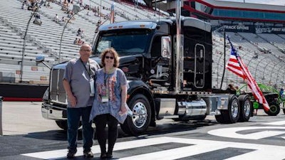 Bob Foran, left, and his wife Dina, right, stand with Bob’s new Peterbilt. (Image Courtesy of Montgomery Transport)