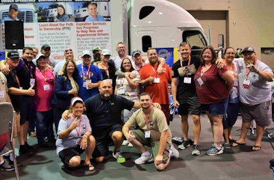 Transportation Life group members pose for a photo by the Expediter Services booth at Expedite Expo, where Paxton’s award was announced Saturday.