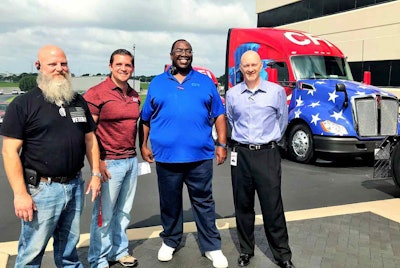 Selected to drive the “True to the Troops” trucks are four military-service veterans at CFI, two of whom are pictured here. From left: CFI drivers Michael Slack of Lebanon, Mo., and Josh Armstrong of Leland, N.C.; also pictured are Darrel Bogan, who has driven the original “True to the Troops” truck since 2015, and CFI President Greg Orr. The other two truckers chosen to drive to two new units are Tom Christian of Austin, Texas, and Scott Bell of Boroda, Mich.