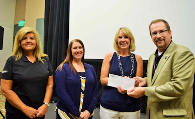 NAIT’s David King presented a check to Wreaths Across America’s Debbie Sparks at the Great American Trucking Show in Dallas Aug. 23. Also pictured, from left: NAIT’s Mona Brimeyer and Corrina Noyez.