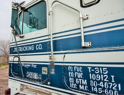 The door latch is on the side of the cab, not on the door. Like most trucks, it came from the factory with the turn signal lever held on to the steering column with a radiator hose clamp. It has a huge Diamond Reo steering wheel, so the driver can have extra leverage. Lighted steps. This truck is complete — really nice parked condition, with no parts removed.