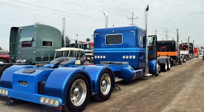 Earnest hauls in the blue custom 2007 Peterbilt 379 in foreground of this line of three Halcomb Farms Petes, headed by the 2015 Kenworth Icon 900 W900L, no. 84 ever built, of Ken Hall, leased to Tralo of Owatonna, Minn. The four trucks all haul with Tralo, whose owner is on hand for this year’s event as well.