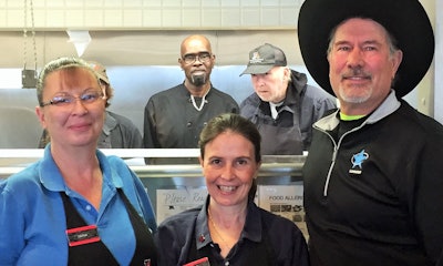 Gary Buchs (right) with TA Bloomington restaurant staff, including longtime servers on the front row, from left to right: Diane with 26 years’ experience there, and Lisa with 32 years. Back in the kitchen is, right to left, Jim with 19 years experience, Tony new this year, and John, with 28 years and obscured by his colleague Diane in the front.