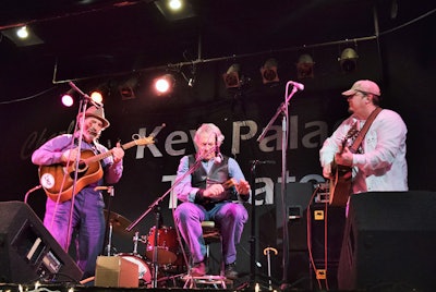 Four songs from occasional Overdrive Extra blog contributor “Long Haul Paul” Marhoefer‘s performance from the stage at the Key Palace Theater in Redkey, Ind., this past Feb. 2. Pictured here are Marhoefer (left) with Indianapolis-based photographer and sometime spoons player Larry Gindhart (center), who joined Marhoefer and New Castle, Ind.-based luthier Sherman Stockton.