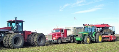tractors and truck parked in field