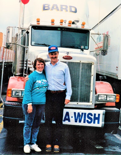 George and Diana Ruelens having picture taken outside of peterbilt truck